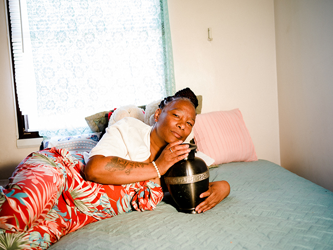 LaTonya Moore poses with her daughter’s urn, Shantieya Smith, inside her home 150 miles away from Chicago.